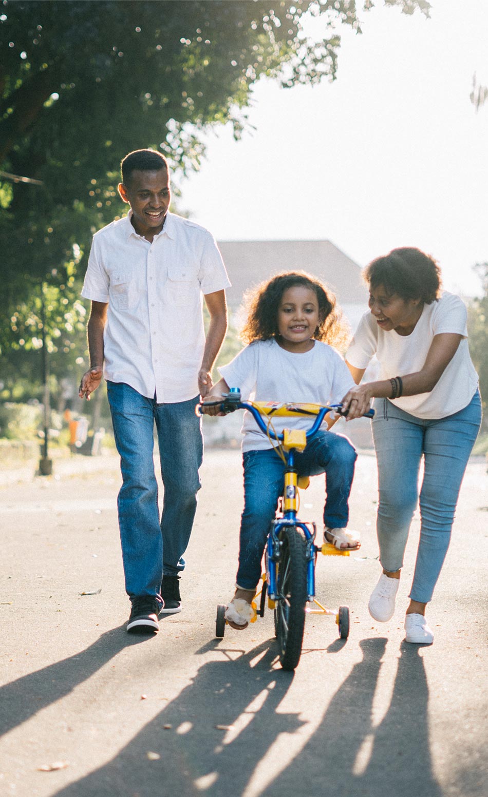 Parents teaching kid to ride a bike